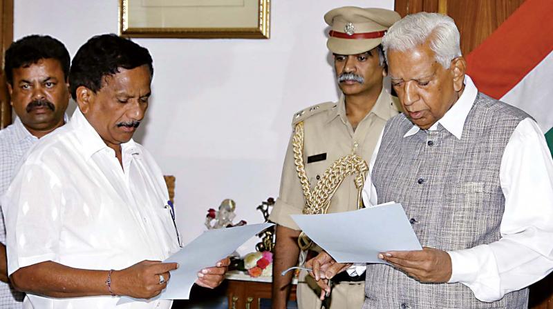 Former Speaker K.G. Bopaiah takes oath as interim Speaker from Governor Vajubhai Vala at Raj Bhavan in Bengaluru on Friday. (Photo: DC)