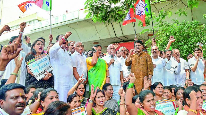 Karnataka BJP president and former chief minister B.S. Yeddyurappa, MP Shobha Karandlaje, MP P.C. Mohan with other leaders shout slogans against the alliance of JD(S) and Congress as they observe Anti-Peoples Mandate Day on Wednesday. (Photo: PTI)