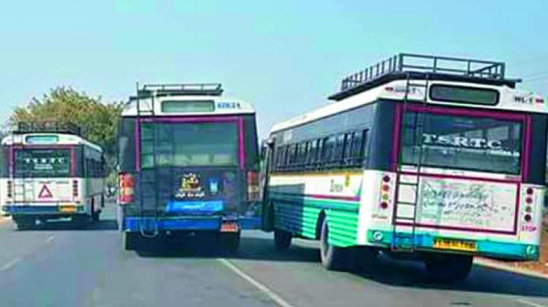 Two RTC buses trying to overtake another one on their left at the same time on Karimnagar-Warangal highway on Tuesday.