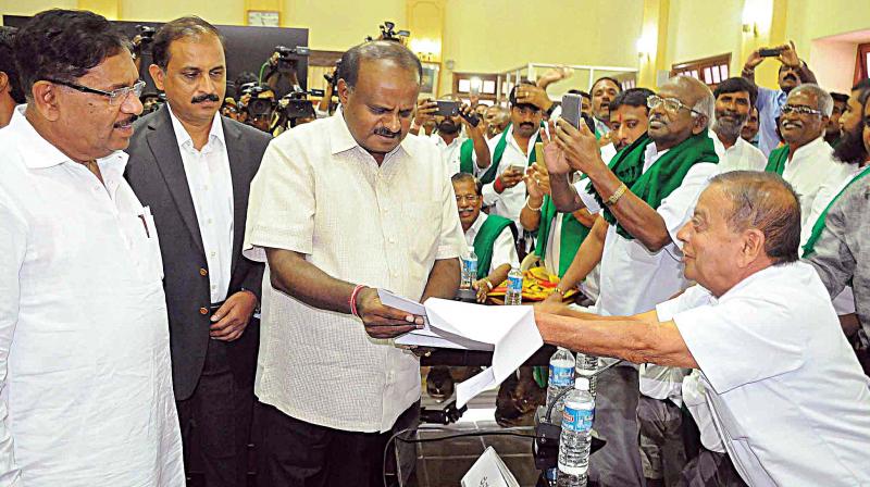 Chief Minister H.D. Kumarswamy and Deputy Chief Minister Dr G. Parameshwar with farmer leaders at a meeting at Vidhana Soudha in Bengaluru on Wednesday. (Photo:  DC)