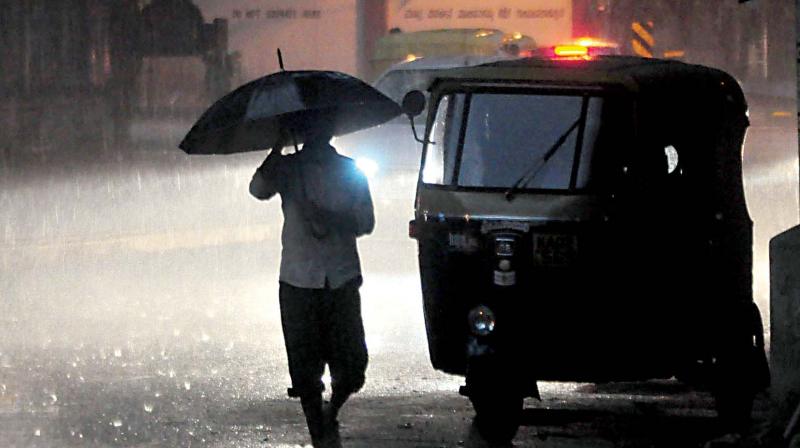 Vehicles pass through flooded streets of Chamarajpet after the city witnessed a heavy downpour on Friday evening. (Photo: KPN)