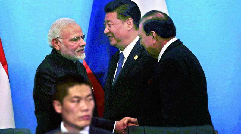 PM Narendra Modi shakes hands with Pakistan President Mamnoon Hussain as Chinese President Xi Jinping looks on at a joint press conference for the Shanghai Cooperation Organisation Summit in Qingdao in eastern Chinas Shandong Province on Sunday. (Photo: PTI)