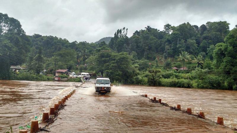 The bridge connecting Kalasa-Mudigere overflows as River Bhadra is full to its capacity in Chikkamagaluru. (Photo: DC)
