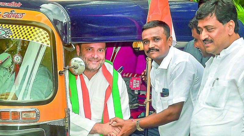 Congress  President Rahul Gandhi shakes hands with an auto-rickshaw driver before a meeting, in Mumbai on Tuesday. (Photo: PTI)