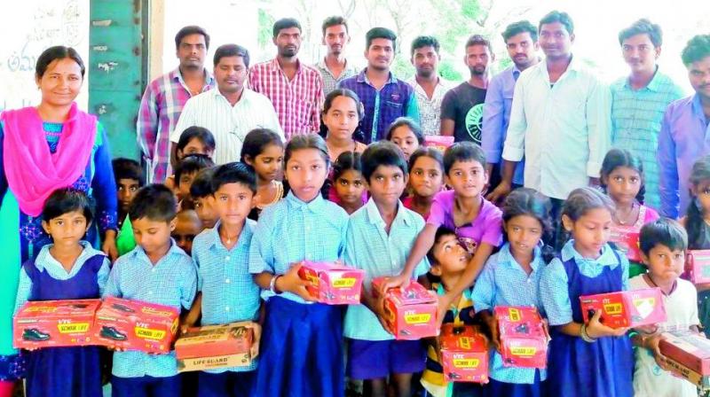 Students of Kondailupalli government school with the shoes donated to them by members of the Yuvatha Meluko Foundation. (Photo: DC)