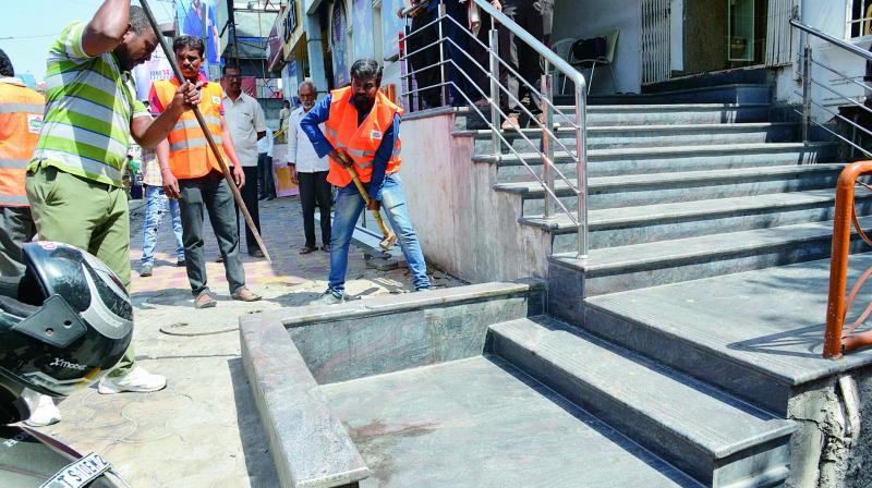A GHMC team in action removing an encroachment on a footpath on Saturday.