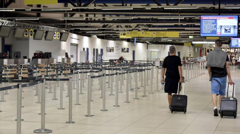 Passengers walk through the empty departure hall of the Schoenefeld airport near Berlin on Friday. (Photo: AP)