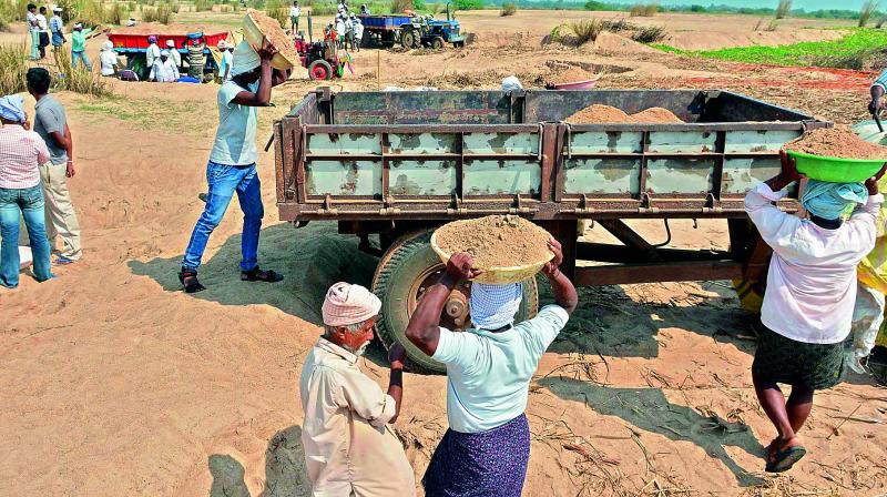 Sand being loaded on tractors at Lankapalli Agricultural patta lands in Krishna district on Friday. 	(Photo: Ch. Narayana Rao)