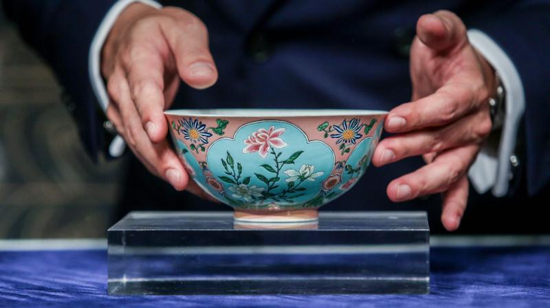 Nicolas Chow, deputy chairman for Sothebys Asia, holds an extremely rare Qing Dynasty bowl -- one of only three known to exist -- during a media preview at Sothebys in Hong Kong on April 3, 2018. (Photo: AFP)