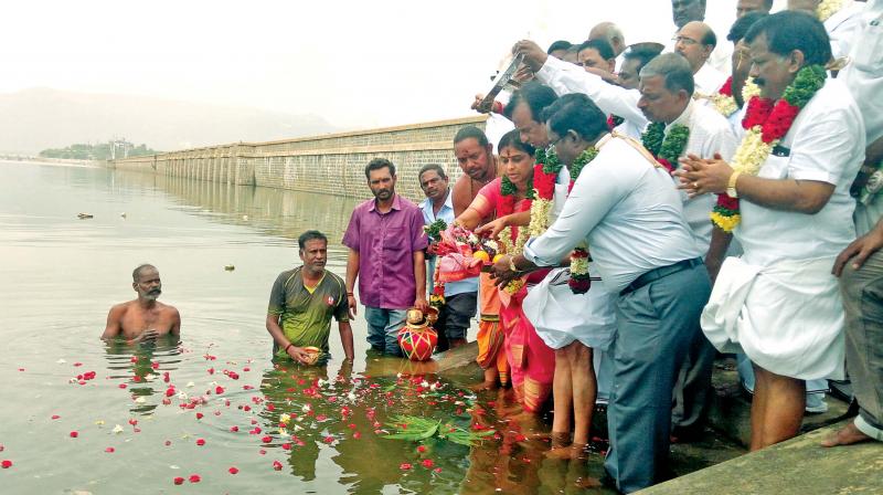 Former AIADMK minister and Mettur MLA Semmalai offers prayers along with PWD officials at Mettur as the dams water level touches 120-ft on Monday. (Photo: DC)