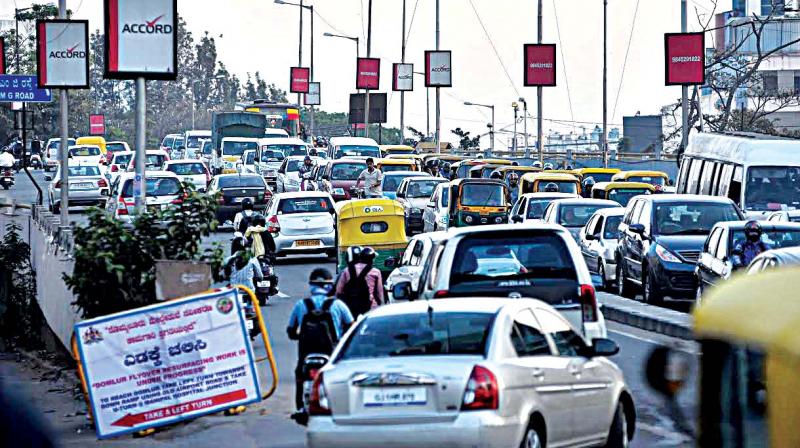 Traffic moves at a slow pace as one of the roads to the fly over on old Airport road near Indiranagar is closed for asphalting, in Bengaluru on Wednesday. (Picture courtesy- Shashidhar B)