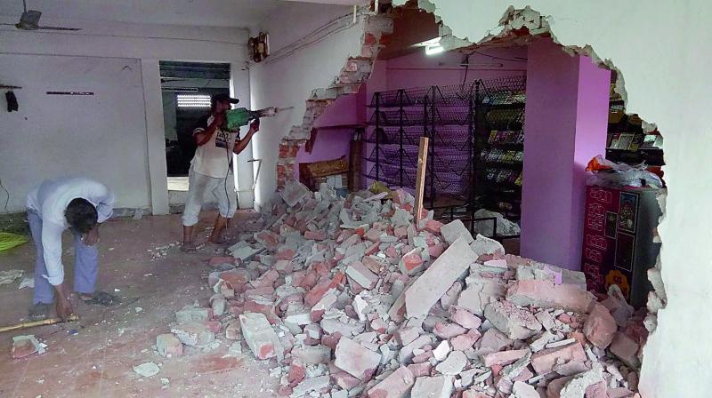 Town planning staff of Guntur Municipal Corporation demolishing illegal structures in the cellar of a commercial complex in Guntur on Tuesday. (Photo: DC)