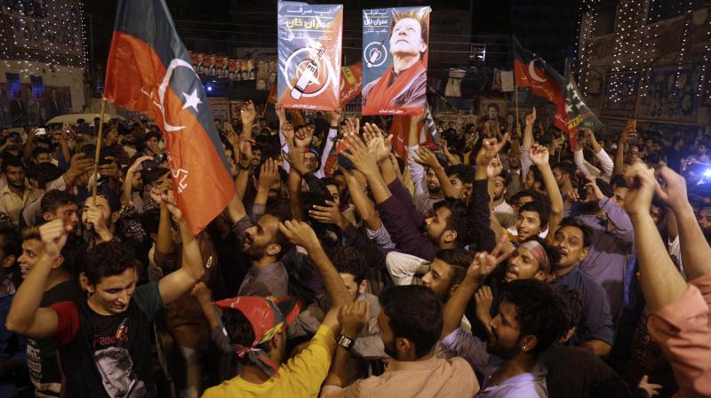 Supporters of Pakistani politician Imran Khan, chief of Pakistan Tehreek-e-Insaf party, celebrate projected unofficial results announced by television channels indicating their candidates success in the parliamentary elections. (Photo: AP)
