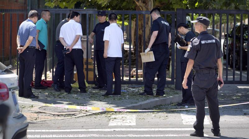 Officials and security personnel stand near the site of reported blast just south of the US Embassy in Beijing. (Photo: AP)