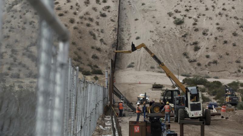 In this file photo, workers continue work raising a taller fence in the Mexico-US border area separating the towns of Anapra, Mexico and Sunland Park. (Photo: AP)