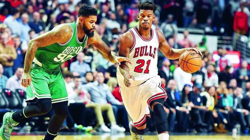 Jimmy Butler of Chicago Bulls dribbles against Amir Johnson of Boston Celtics on Thursday. (Photo: AFP)