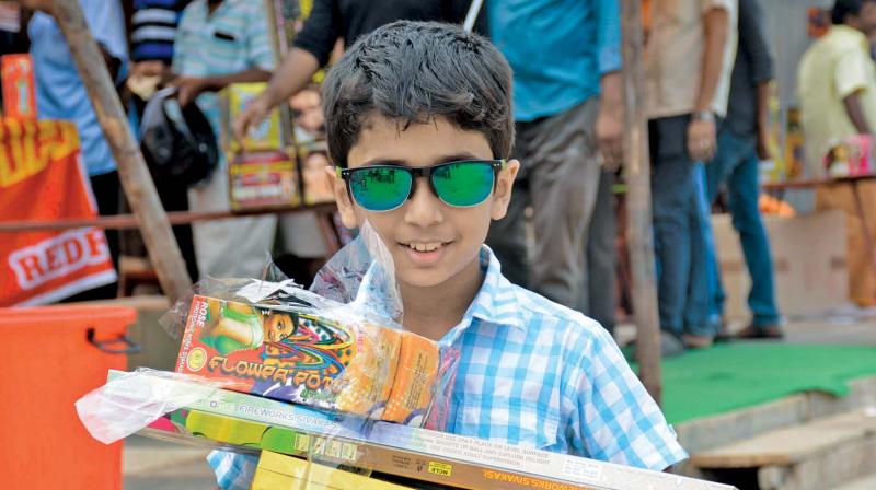 A boy expresses joy as he leaves a shop with a pile of crackers at Island Grounds on Friday. (Photo: DC)