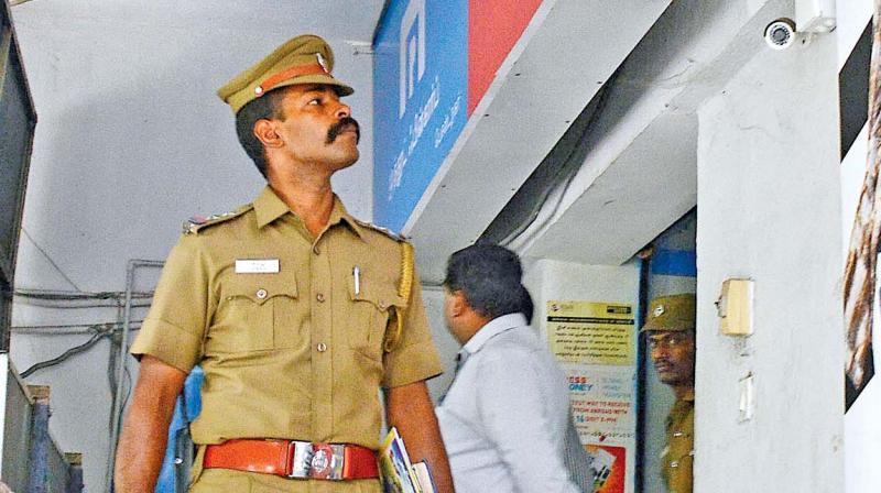 A cop inspecting the Muthoot Fincorp outlet where its employees were robbed by a gang which could not lay its hands on valuables and cash present in the locker. (Photo: DC)