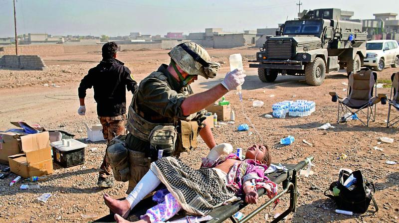 Derek Coleman, centre, a volunteer medic, treats a wounded Iraqi special forces soldier at a field clinic in Gogjali, on the eastern outskirts of Mosul, Iraq. (Photo: AP)