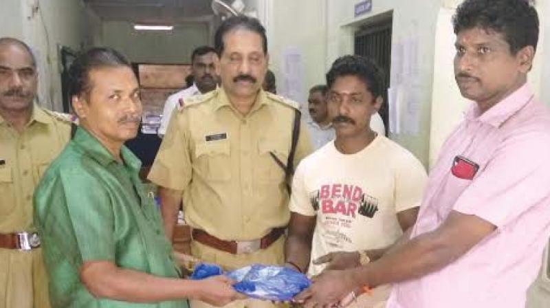 Shaiju (right) returning the bag he found on roadside to K. Santhosh, goldsmith.	DC