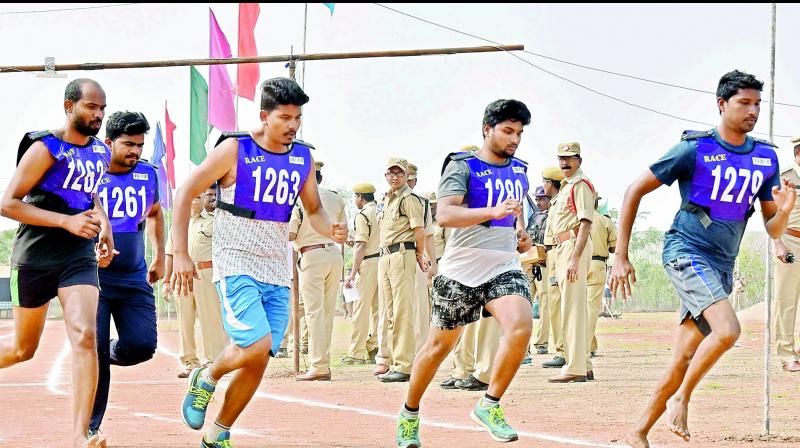 Candidates aspiring for the police constable posts participate in the physical fitness test at a police training center. (DC)