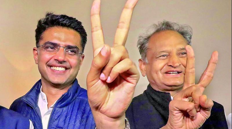 Congress leaders Ashok Gehlot (R) and Sachin Pilot (C) flash victory signs after the declaration of Rajasthan Assembly election result, in Jaipur on Tuesday. 	 PTI