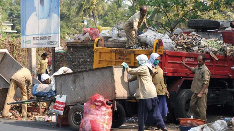 Workers load waste piled up on roads onto trucks on Saturday. FILE PIC