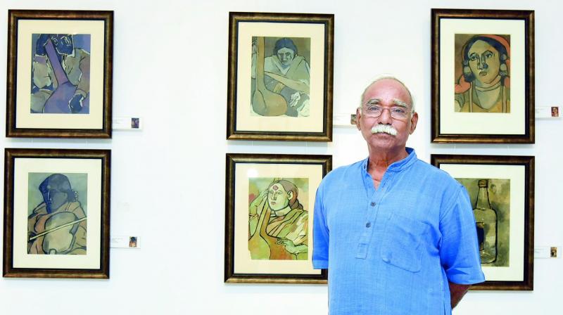 Artist Thota Vaikuntam standing with some of his earliest works from the 1970s, that were heavily inspired by music.