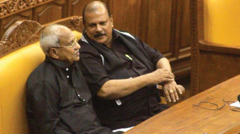 P. C. George having a word with BJP legislator O Rajagopal in House on Wednesday. Both came to the Assembly wearing black dress as a mark of protest against the prohibitory orders clamped by the government in Sabarimala.