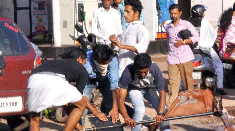 BJP activists seen destroying CPM party flags and flagstaff during their protest march at Palayam in Kozhikode on Friday. 	(Photo:  DC)