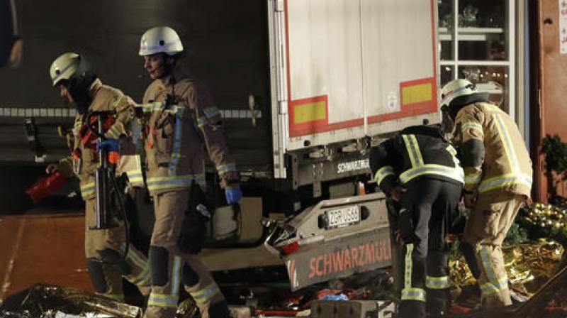 Firefighters inspect the site after a truck ran into a crowded Christmas market and killed several people in Berlin, Germany. (Photo: AP)