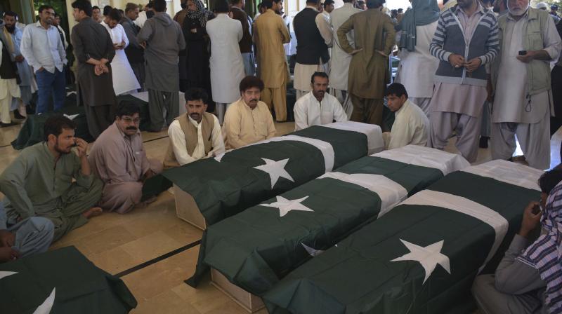 People wait to receive the bodies of their family members who died in an attack on the Police Training Academy, in Quetta, Pakistan. (Photo: AP)