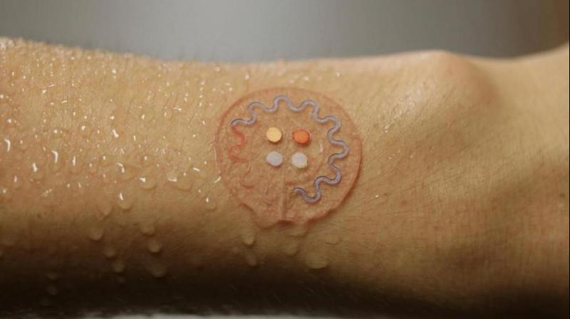 This photo provided by J. Rogers, Northwestern University, shows a soft, skinâ€mounted microfluidic device for capture, collection and analysis of sweat. (Photo: AP)