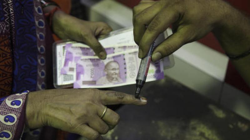 A post office employee puts a mark on the index finger of a woman who exchanged discontinued currency notes in Hyderabad. (Photo: PTI)