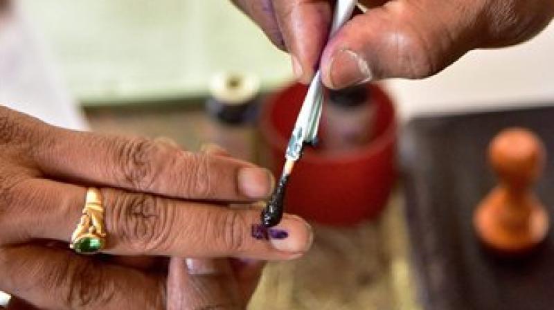 A bank official applies indelible ink on the finger of a customer after withdrawing an amount at the State Bank. (Photo: PTI)