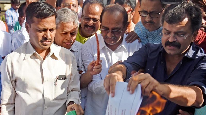 Maharashtra opposition leaders burn the copy of budget demanding loan waiver for farmers after finance minister Sudhir Mumgantiwar presented state budget in Mumbai. (Photo: PTI)