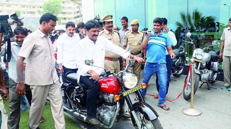 HRD minister Ganta Srinivasa Rao rides an Enfield bike at the launch of Bikes for Rent by Bengaluru-based startup in Visakhapatnam on Thursday.