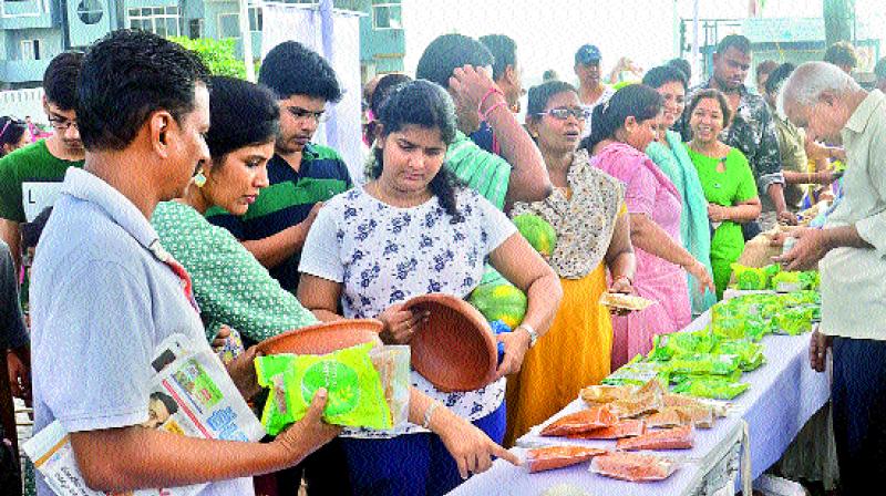 People purchase organic vegetables, fruits and other products at the Organic Farmers Market near YMCA on the Beach Road in Visakhapatnam on Sunday. The market was set up for the first time on the Beach Road to attract morning beach walkers. (Photo: DC)