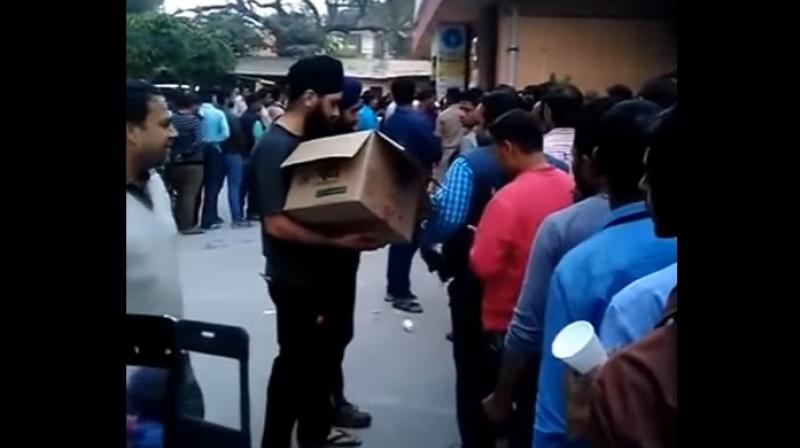 Some members of the Sikh community have come to the common mans rescue by distributing tea and biscuits to the public queuing outside banks and ATM kiosks. (Credit: YouTube)