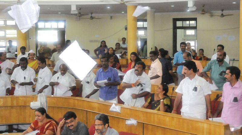 BJP councillors tear the agenda copies  in protest against the Mayors decision to keep discussion on LDF-BJP fight for the latter part of the council meeting .	(Photo: A.V. MUZAFAR)