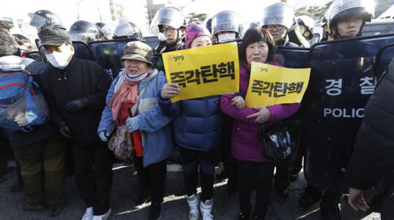 Protesters are pushed by police officers during a rally demanding the parliamentary impeachment of South Korean President Park Geun-hye in front of the National Assembly in Seoul, South Korea. (Photo: AP)