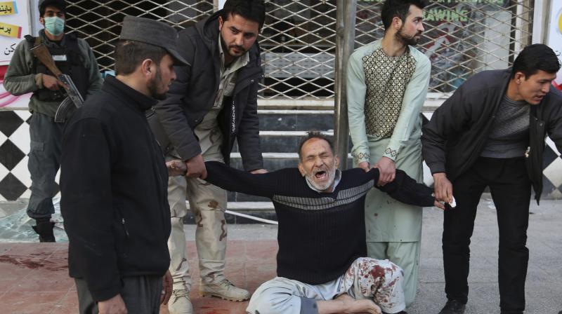 A relative of a victim is helped as he cries after a deadly suicide attack in Kabul. (Photo: AP)