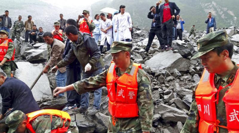 Emergency personnel and local people work at the site of a landslide in Xinmo village in Maoxian County in southwestern Chinas Sichuan Province on Saturday. (Photo: AP)