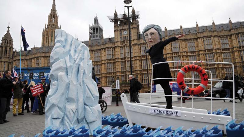 An activist from Avaaz wears a mask of Britains Prime Minister Theresa May as Pro-European demonstrators protest opposite the Houses of Parliament in London on Tuesday.  (Photo: AP)