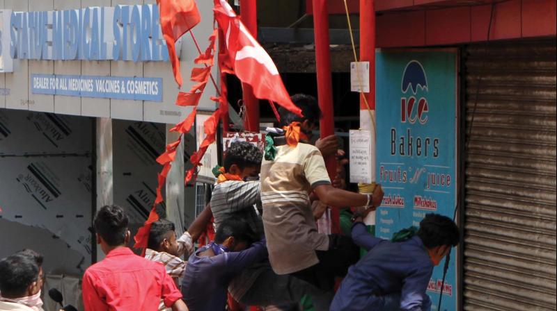 BJP activists destroy the flag posts of Left parties at Statue Jn. during the hartal in Thiruvananthapuram on Thursday. (Photo:  A.V. Muzafar)