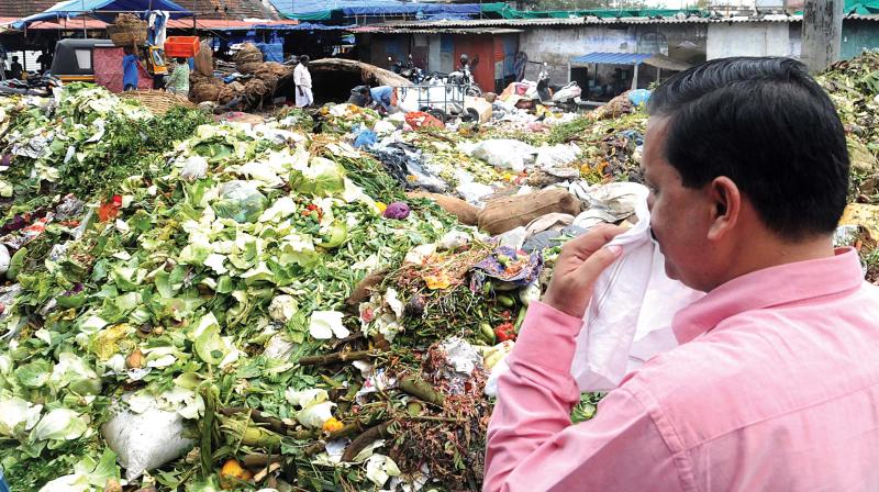 Sub-judge A M Basheer cant resist thumbing his nose at stench emanating from the waste at Ernakulam Market on Tuesday. ARUN CHANDRABOSE