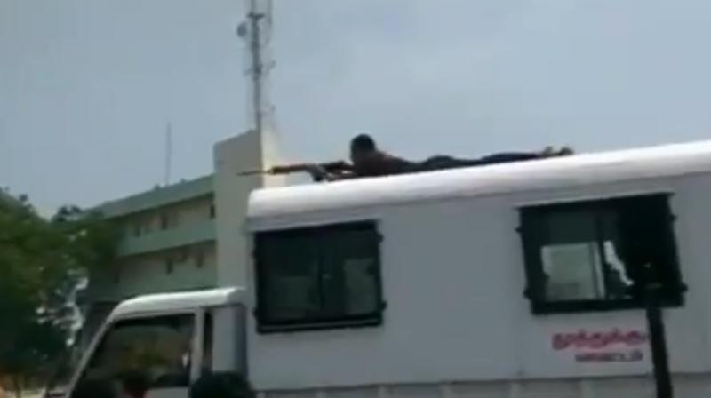 A Tamil Nadu police personnel in plainclothes placing himself atop a police bus, a few meters away from where people had gathered to hold anti-Steralite protest. (Photo: ANI | Screengrab)