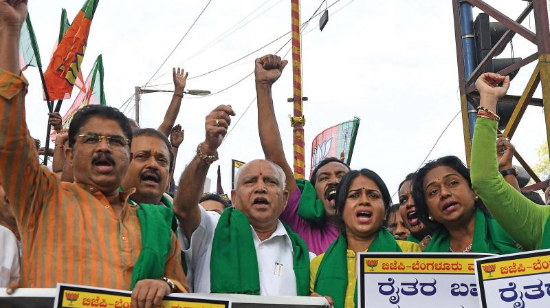 BJP leaders led by B.S. Yeddyurappa, R Ashoka and others stage a protest in support of the sugarcane farmers protesting against the state government at Mysore Bank Circle in Bengaluru on Wednesday DC