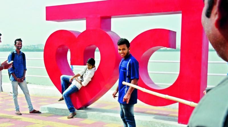 A security guard tries to chase off a youth sitting on the Love HYD tourist structure on Tank Bund on Thursday. Security guards were posted at the â€œselfie spotâ€after some miscreants defaced the structure. (Photo: DC)