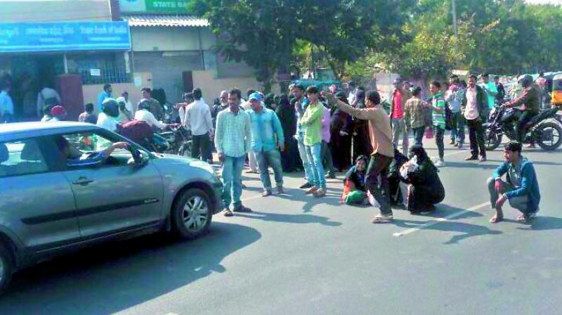 Angry bank customers protest in front of a bank at Kanchanbagh by stopping the vehicles and demanding that the officials address their problems. 	(Photo: P. Surendra)